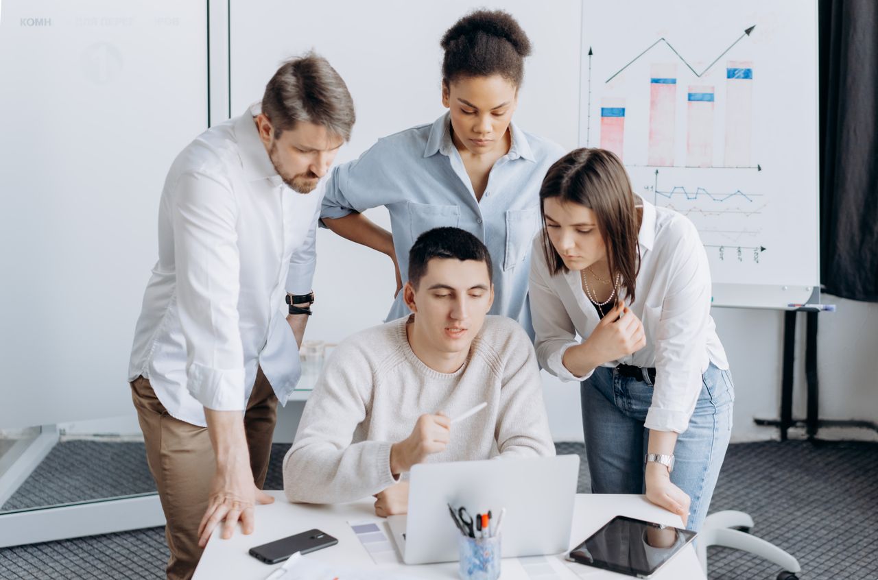 Professionisti collaborano attorno a un computer portatile
