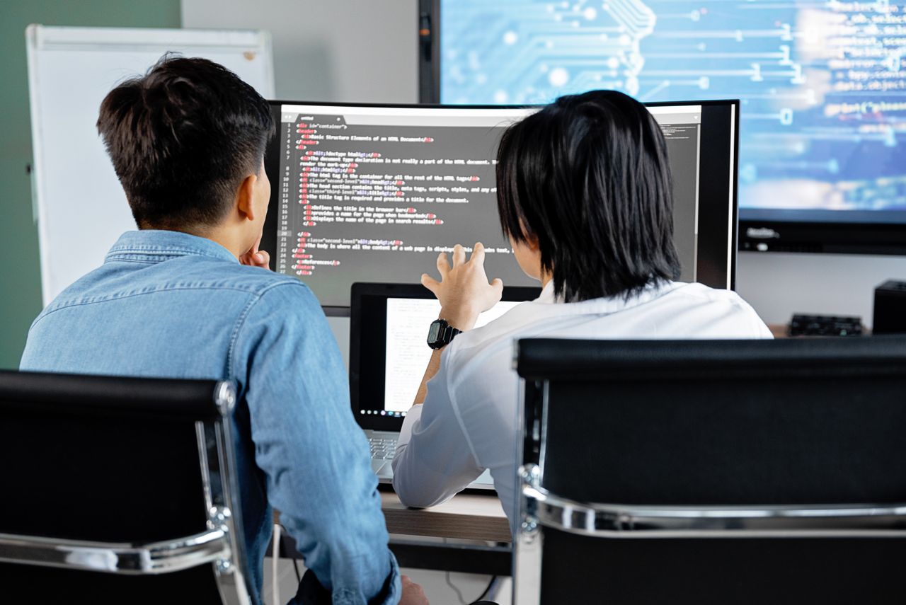 Due persone lavorano insieme sul codice di un’applicazione